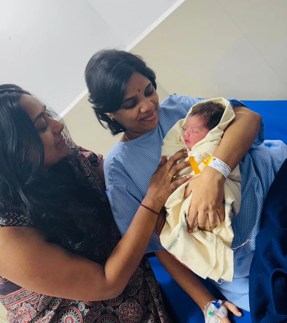 A new mother meeting her baby, held by Dr. Deepthi Raidu after delivery