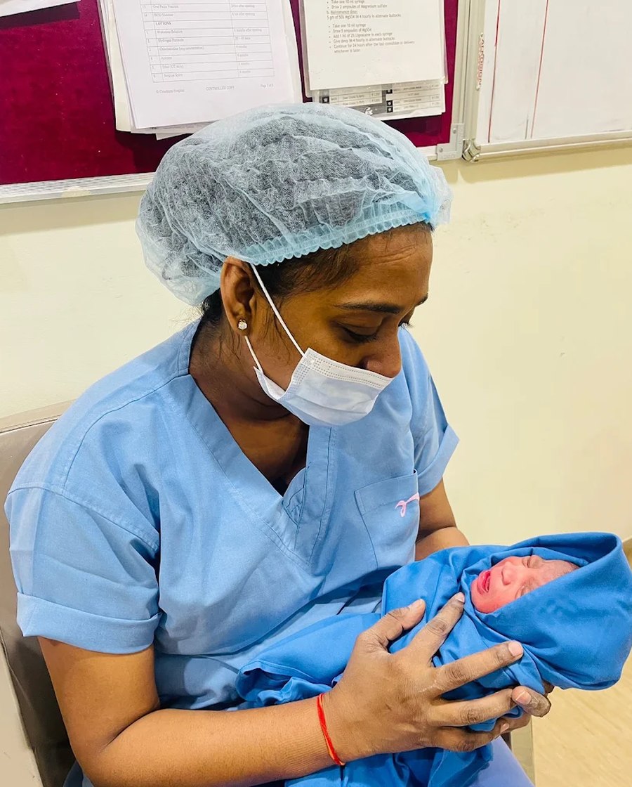 A newborn resting in the arms of the clinic's nursing team